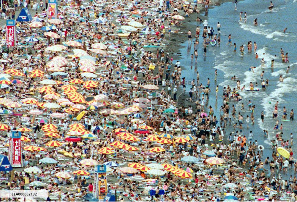 Beach crowded by a number of sea bathers, swimmers