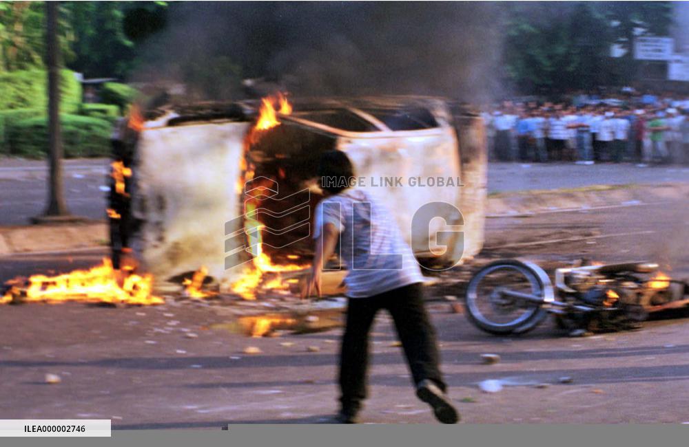 Jakarta protester throws rock at military car