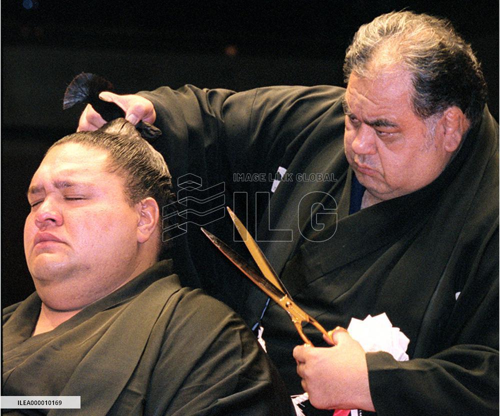 Stablemaster Azumazeki removes the topknot of yokozuna Akebono