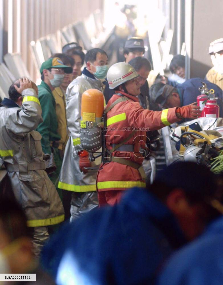 Fire fighters check Narita airport walkway