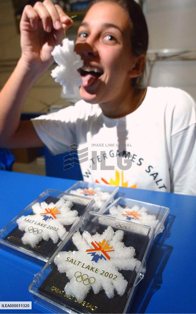 In preparation for the upcoming Winter Olympics, a young woman licks a souvenir made from salt taken from the Great Salt Lake adjacent to the hosting city.  The souvenir costs $9 each.