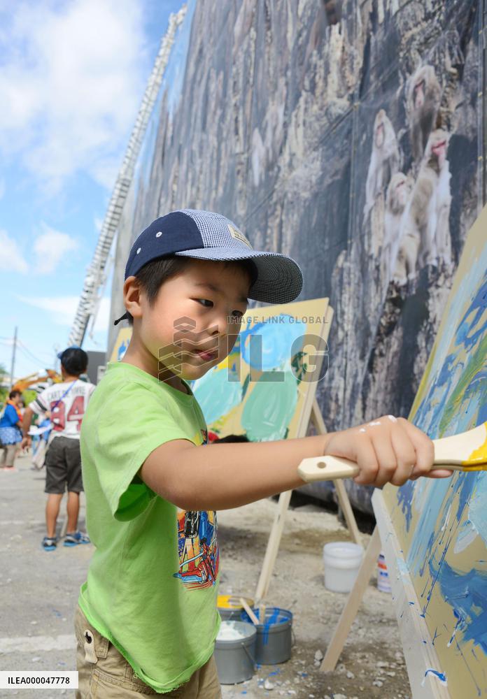 Boy experiences wall painting at construction site