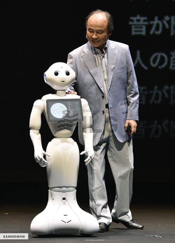 SoftBank head Son stands with "Pepper" humanoid robot