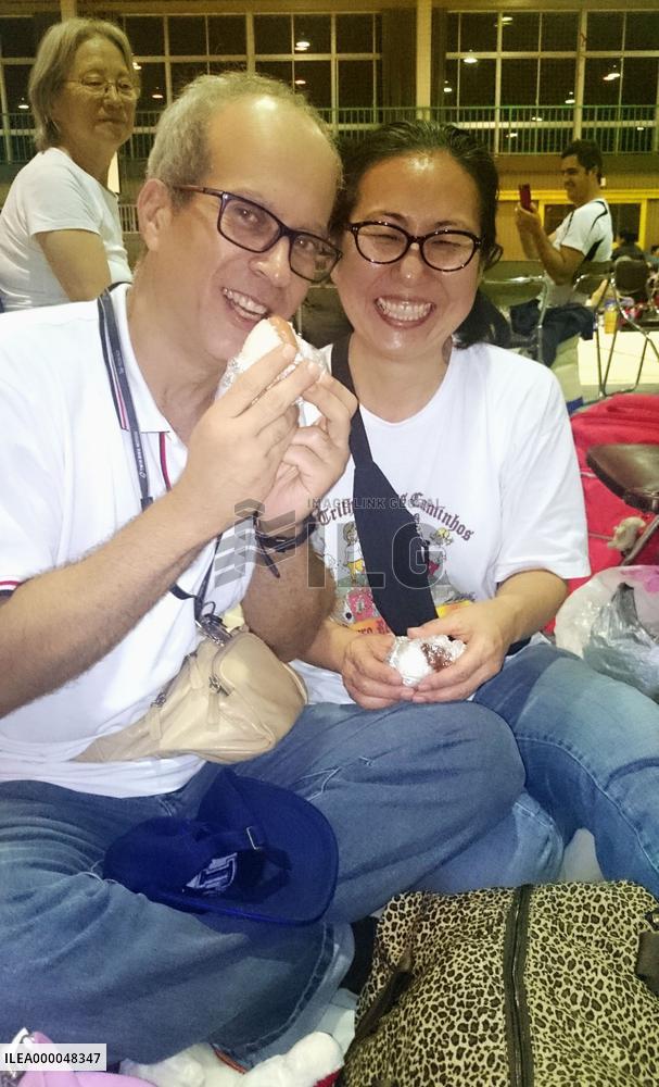Flood-hit Japanese-Brazilian couple eat rice balls at shelter