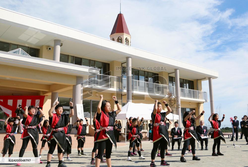 Pupils dance in front of new school building in northern Japan