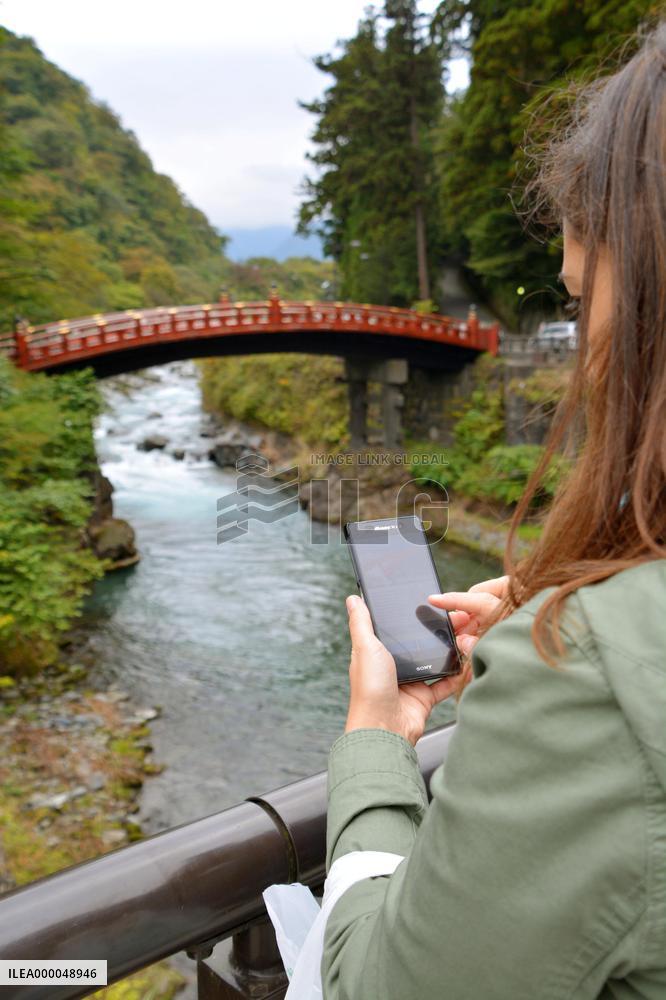 Spanish visitor uses smartphone to get info on Nikko tourist spots