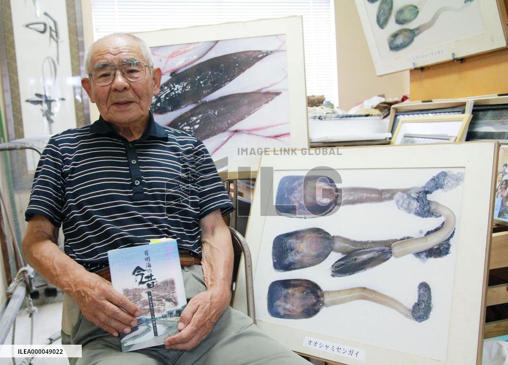 Aquarium owner poses with Ariake Sea product photos
