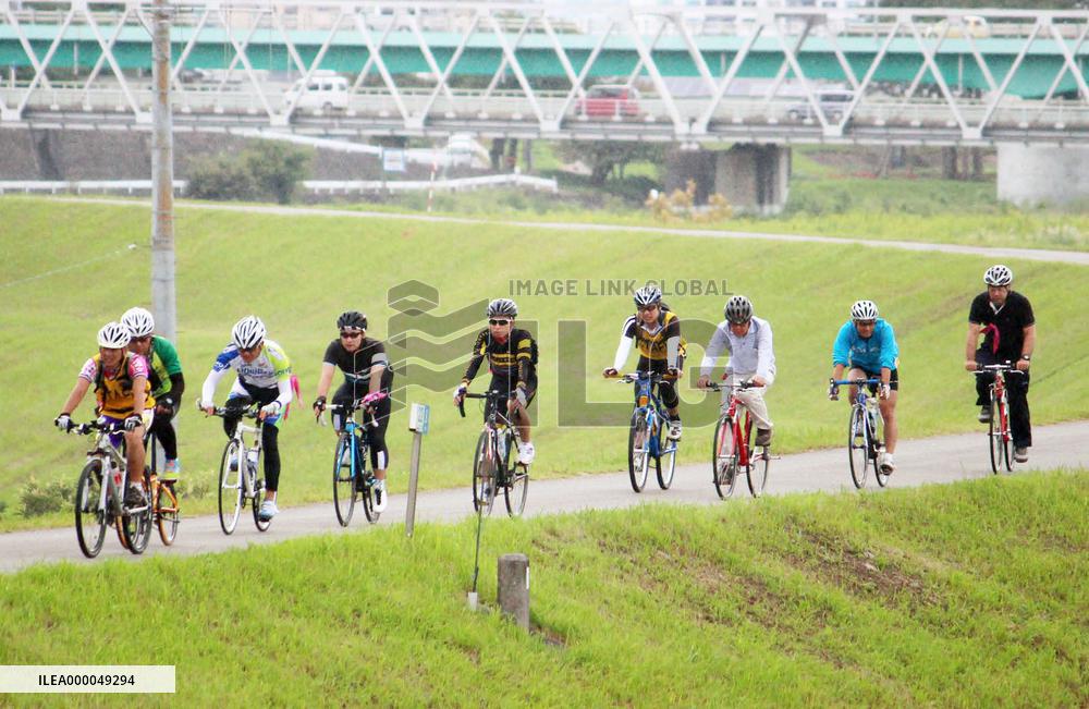 Cyclists pedal on tour along Kano River on Izu Peninsula