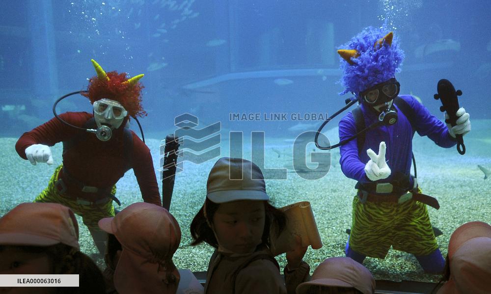 Goblin-mask divers delight kids at aquarium in western Japan
