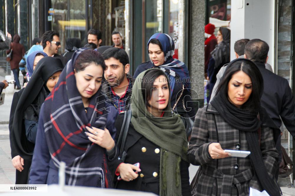 Young Iranian women walk with hair exposed on Tehran street