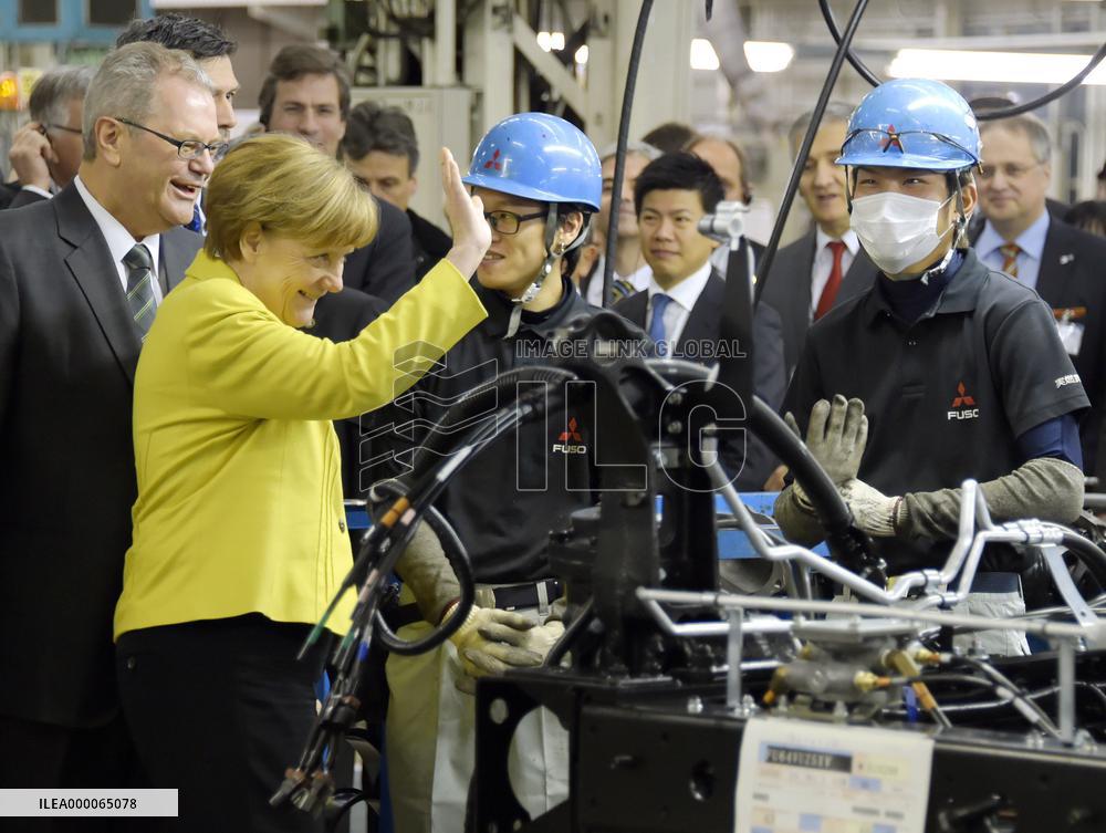Merkel visits truck, bus assembly plant in Japan
