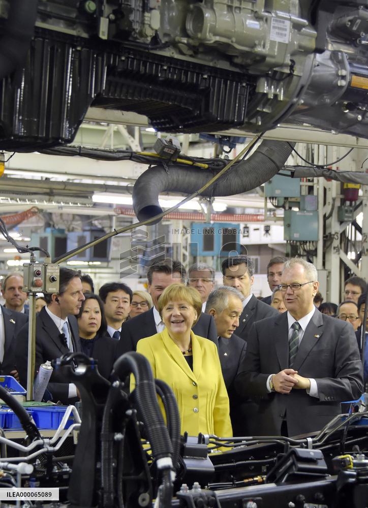 Merkel visits truck, bus assembly plant in Japan