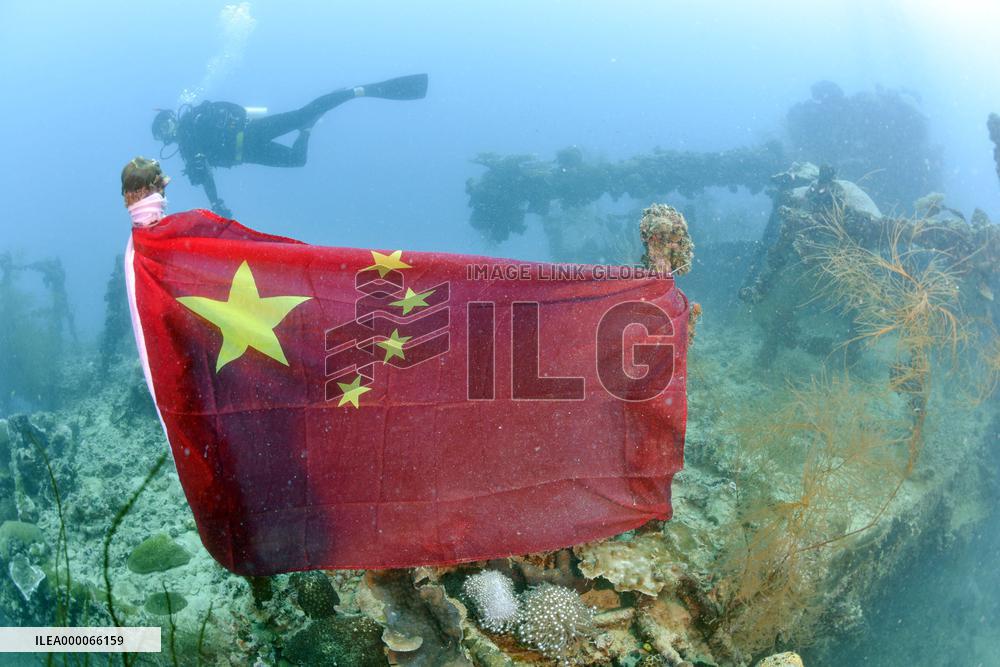 Chinese flag tied onto wreck of WWII Japanese tanker