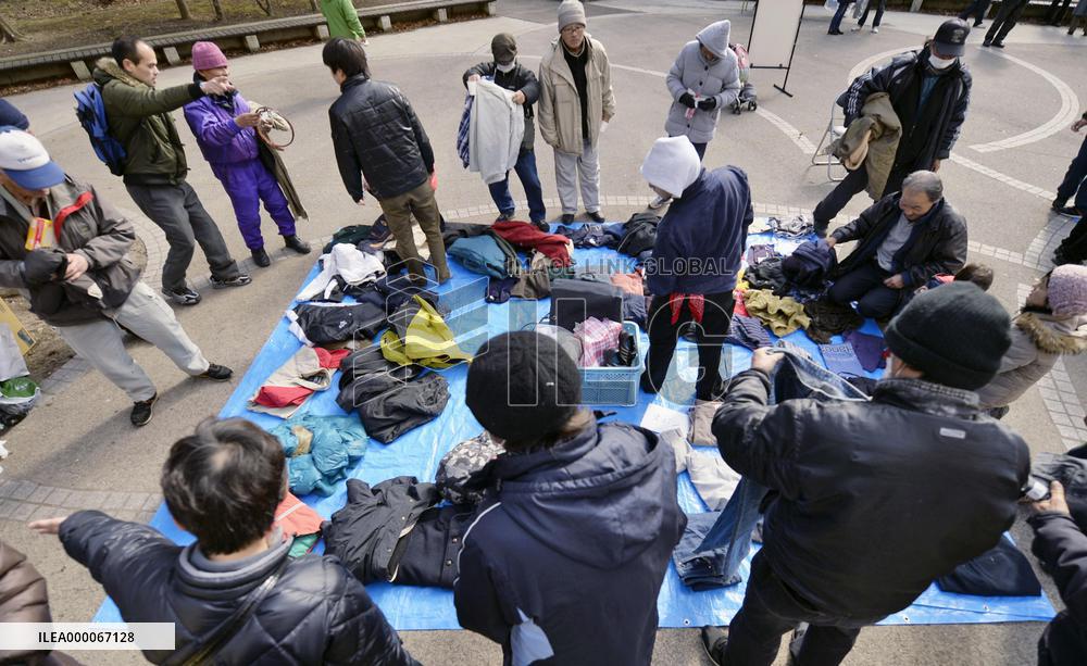 Homeless people pick clothes supplied by support group in Sendai