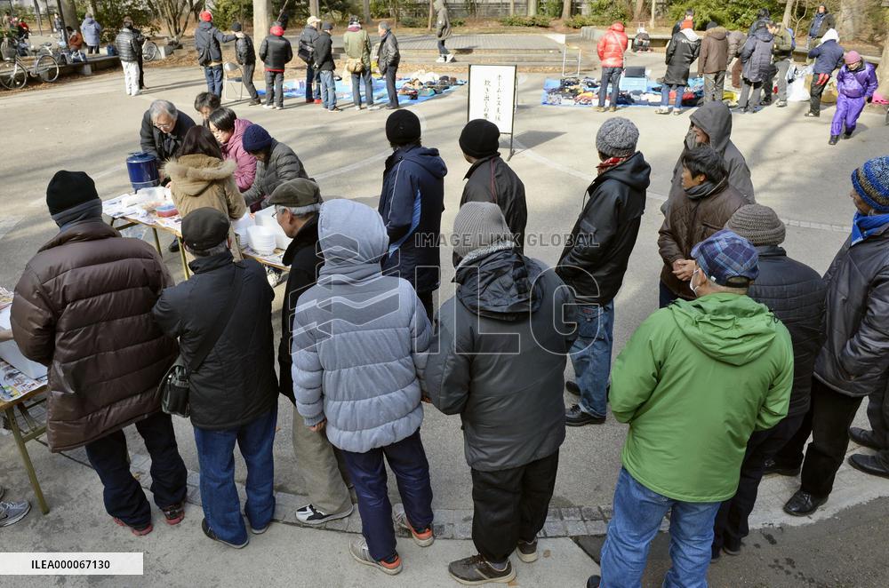 Homeless people wait in line at soup kitchen in Sendai