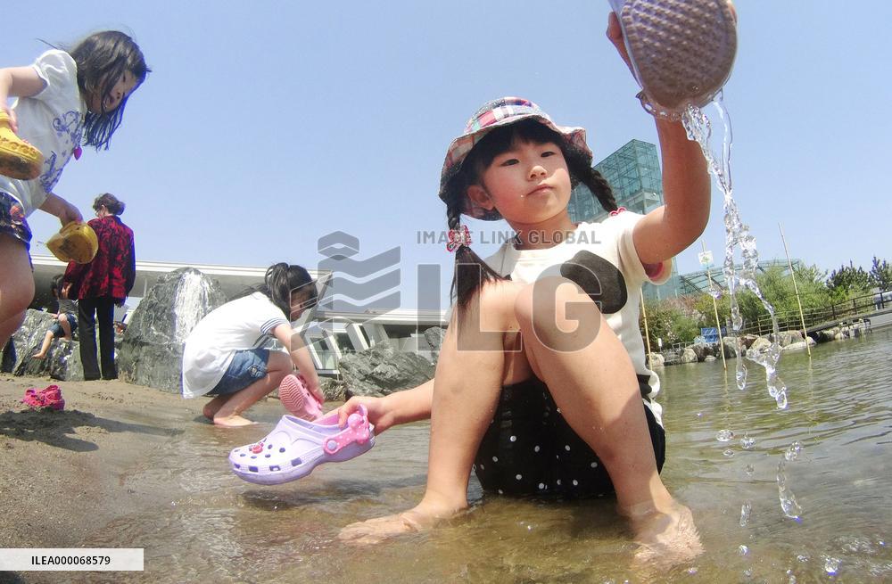 Kids play on man-made beach of Fukushima aquarium