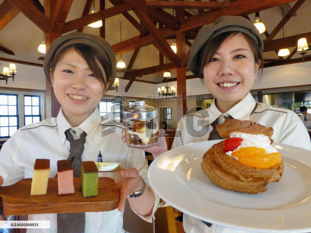Sales clerks show off Japanese sponge cakes at Nagasaki cafe