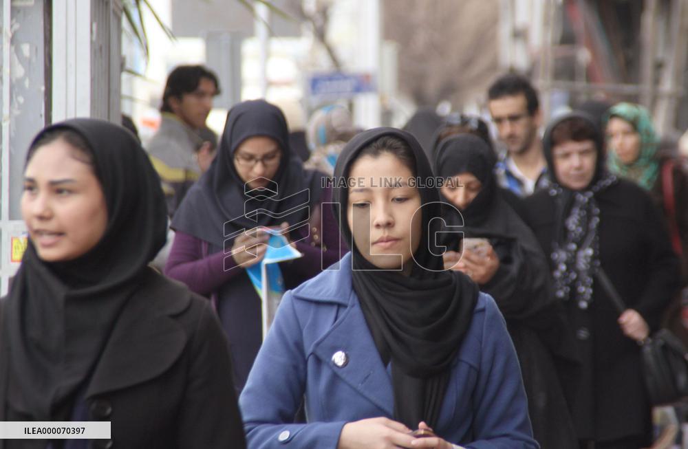 Iranian women walk with headscarves in Tehran