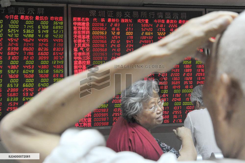 Investors watch quotation board at Beijing brokerage house