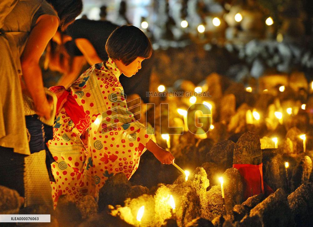 Girl lights up candle during annual service at Kyoto temple
