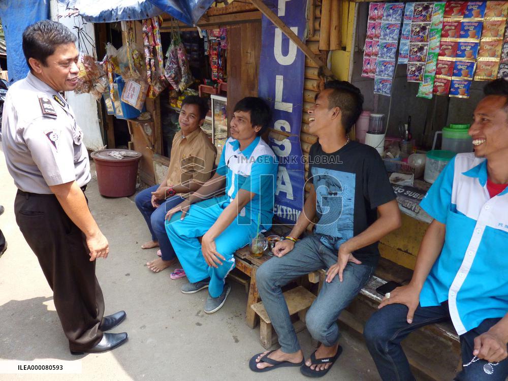 Policeman chats with residents on beat in Jakarta suburb
