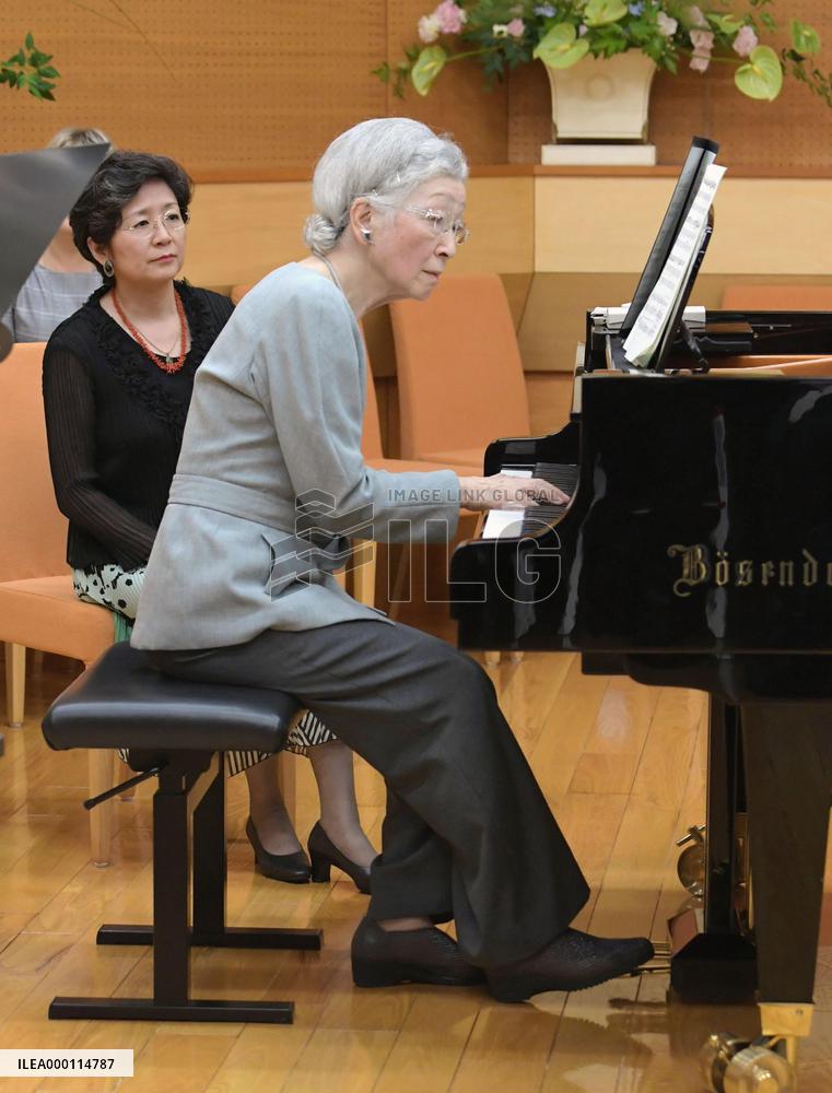 Empress plays piano at music workshop
