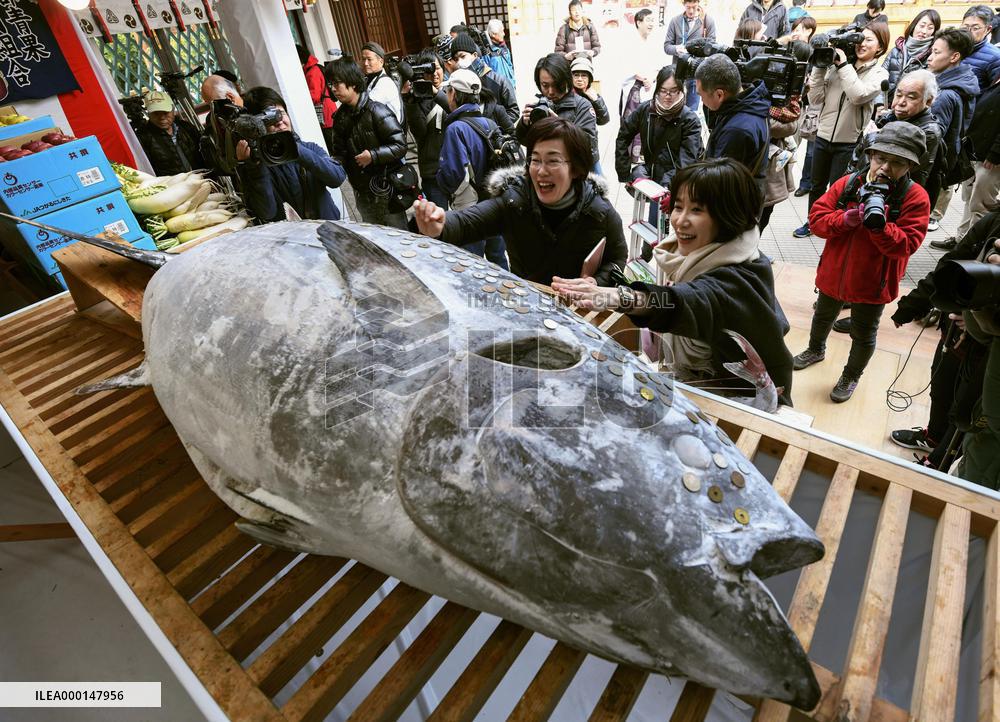 Coins pressed on tuna for good luck in western Japan