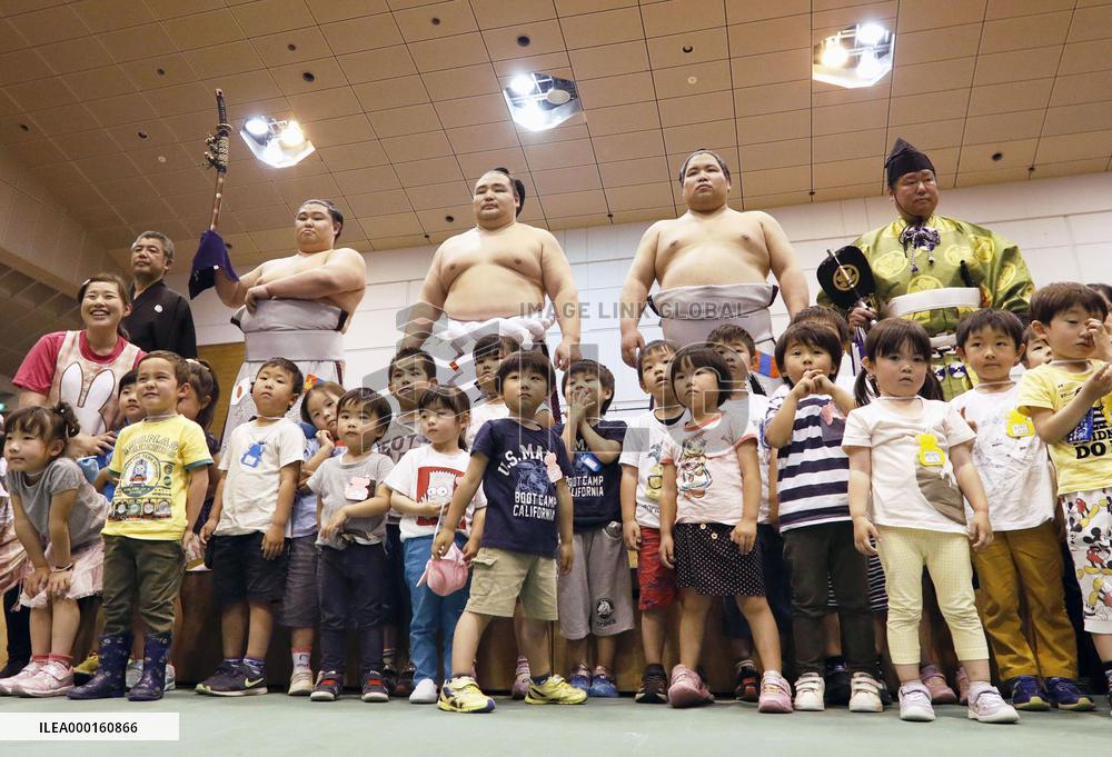 Sumo grand champion visits quake-hit town