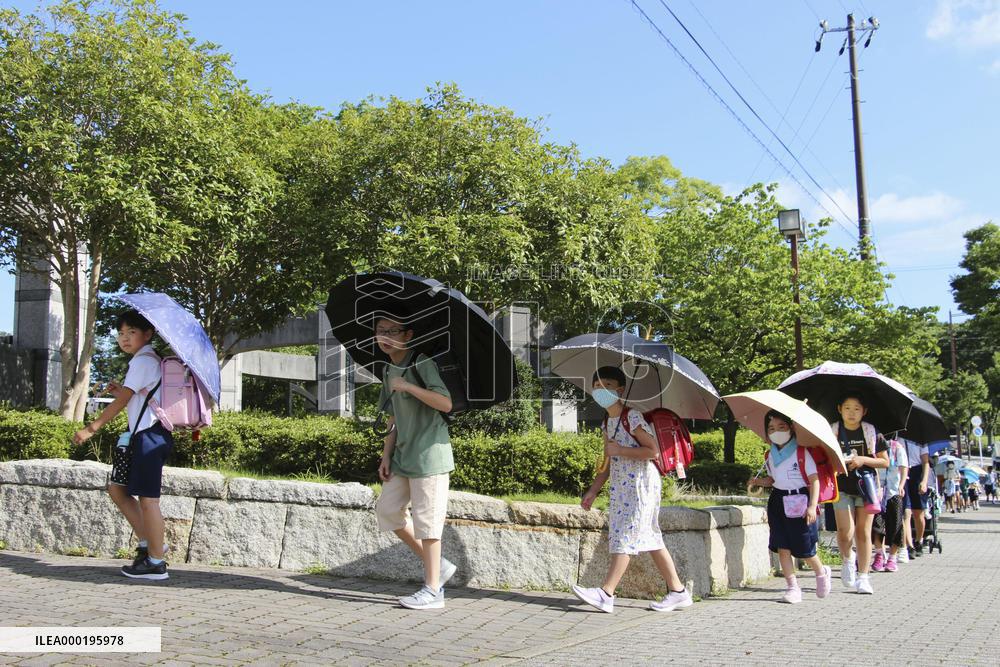 School students with umbrellas in the sun