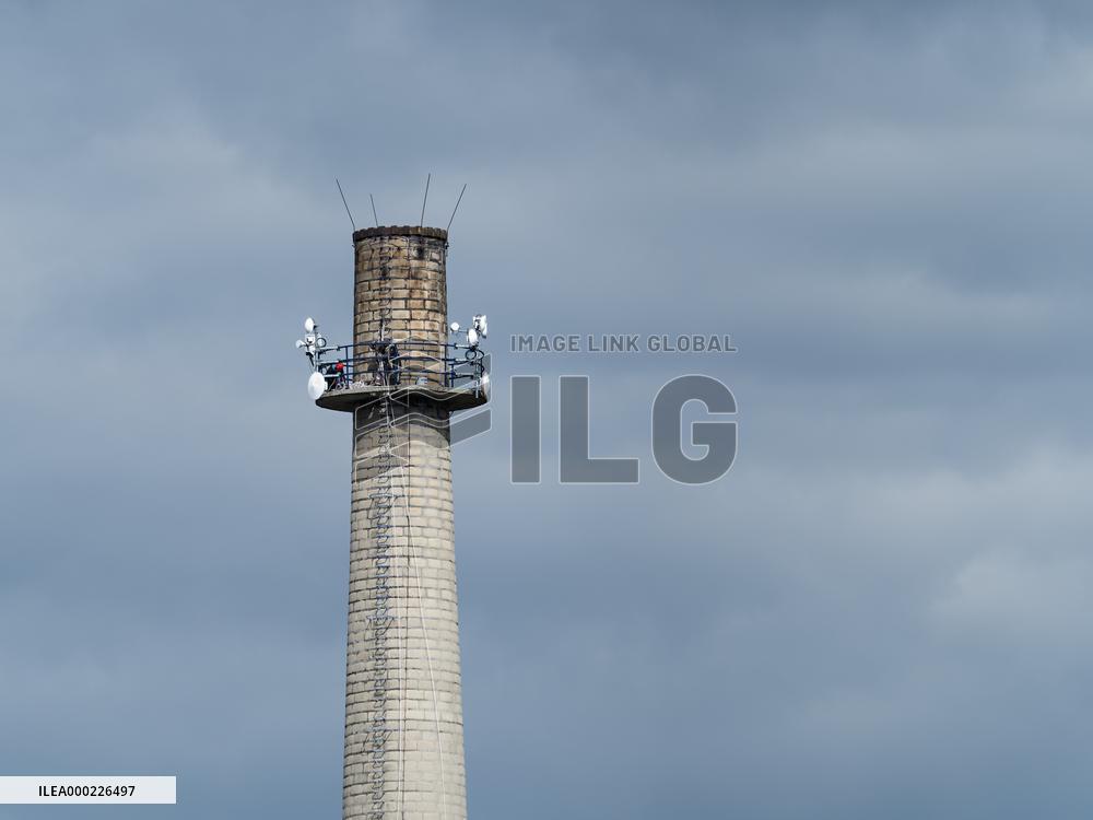 Factory chimney, antennas, stairs, people