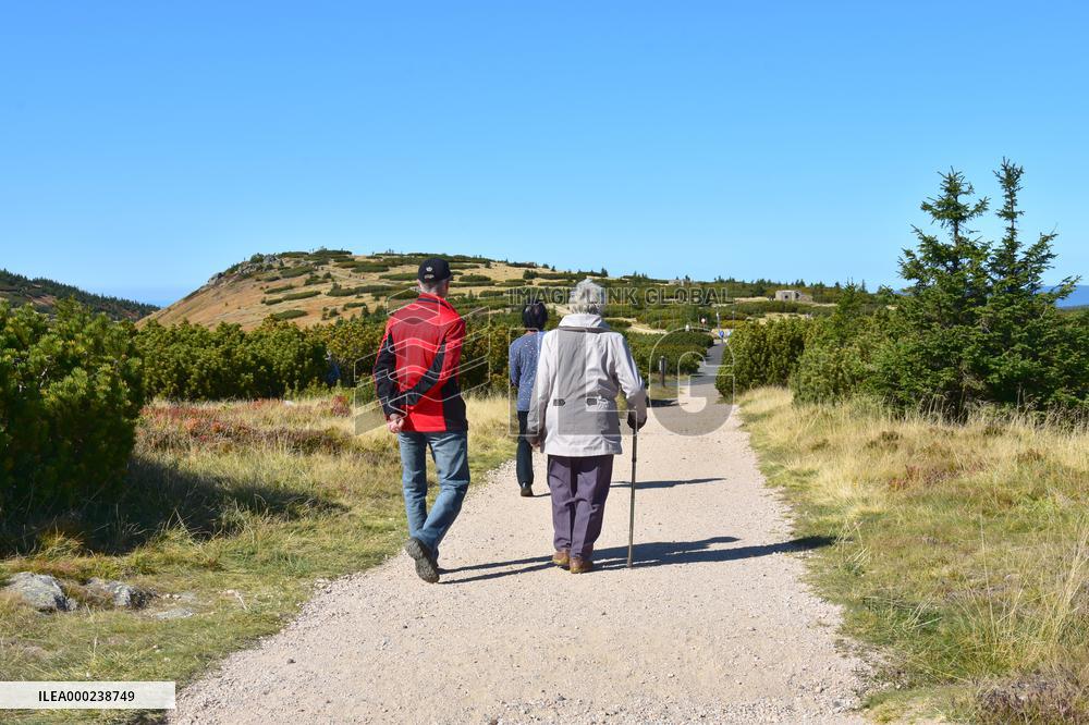 Tourists in the retirement age, hiking, Krkonose Mountains.
