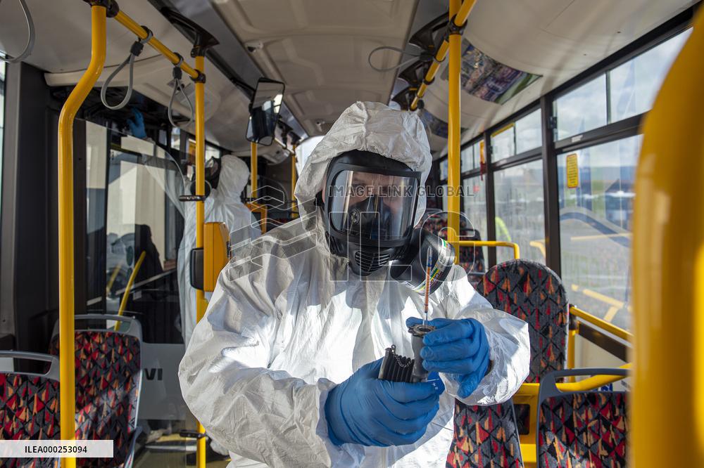 a worker with ozone disinfects a public bus against coronavirus