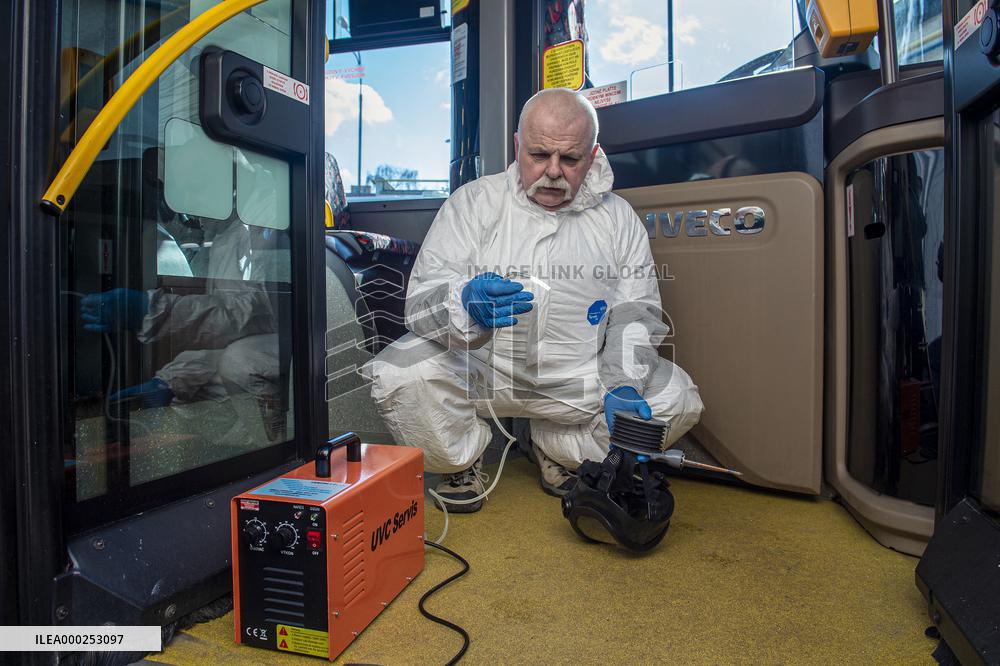 a worker with ozone disinfects a public bus against coronavirus