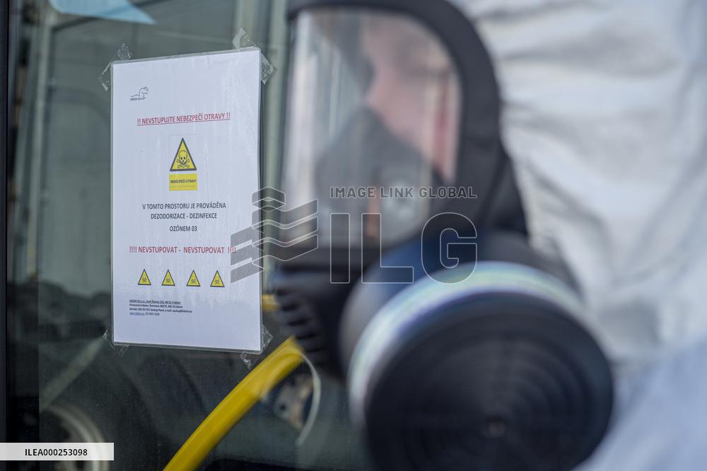 a worker with ozone disinfects a public bus against coronavirus