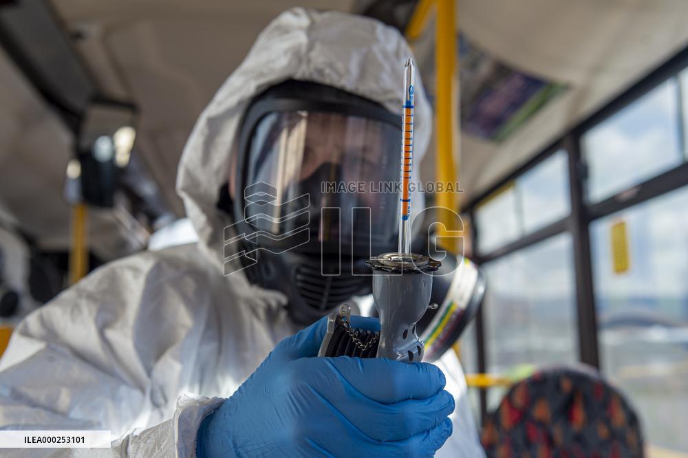 a worker with ozone disinfects a public bus against coronavirus