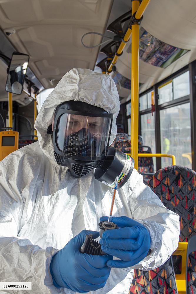 a worker with ozone disinfects a public bus against coronavirus