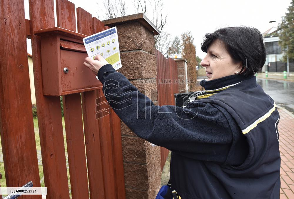 a postwoman distributes information flyers about the novel coronavirus