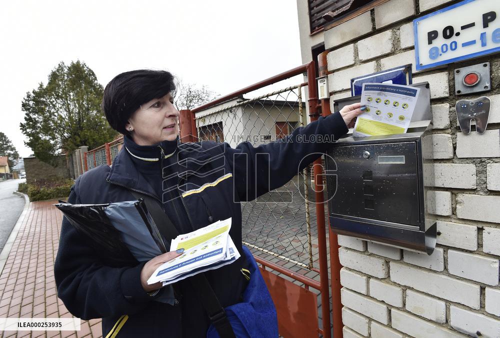 a postwoman distributes information flyers about the novel coronavirus