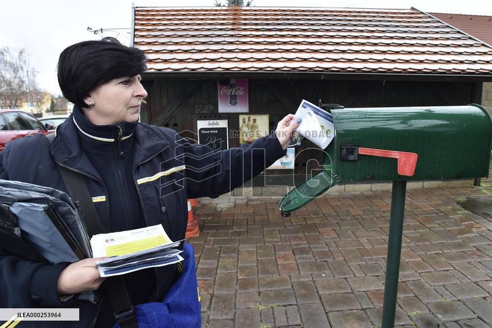 a postwoman distributes information flyers about the novel coronavirus