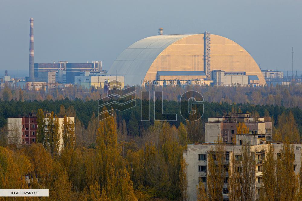 Chernobyl zone, restricted territory, aerial view on deserted town of Pripyat and secure dome over the damaged Chernobyl nuclear reactor number 4