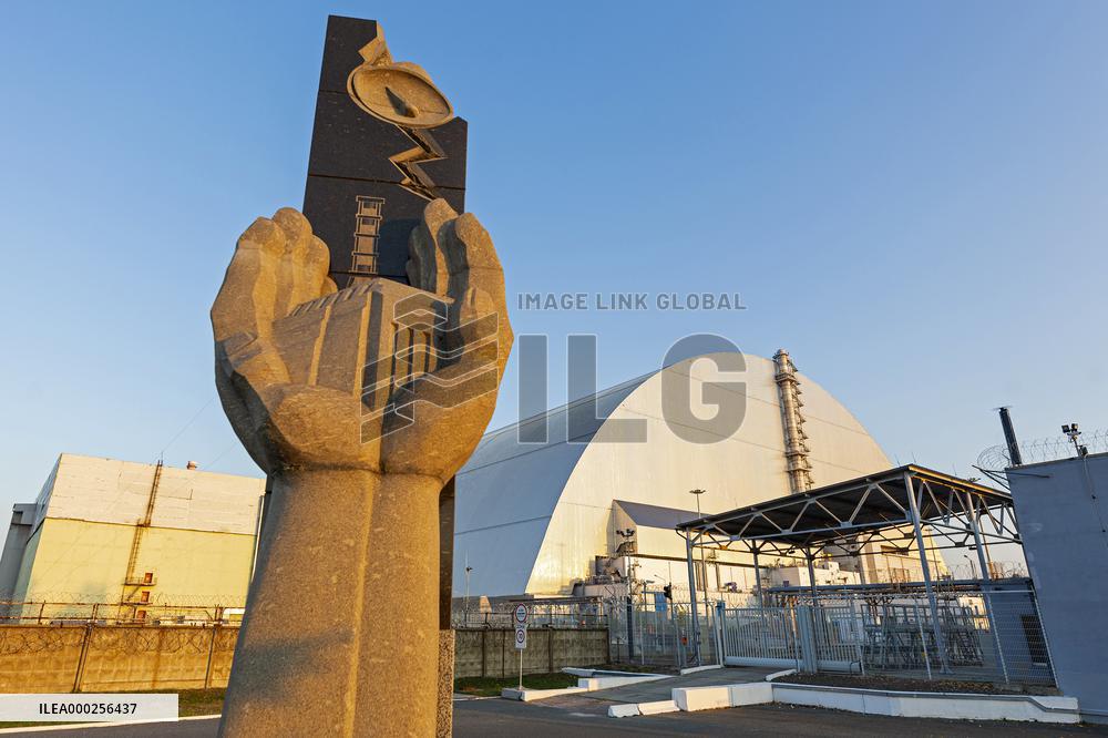 Chernobyl zone, restricted territory, Memorial to the Chernobyl liquidators with secure dome over the damaged Chernobyl nuclear reactor number 4