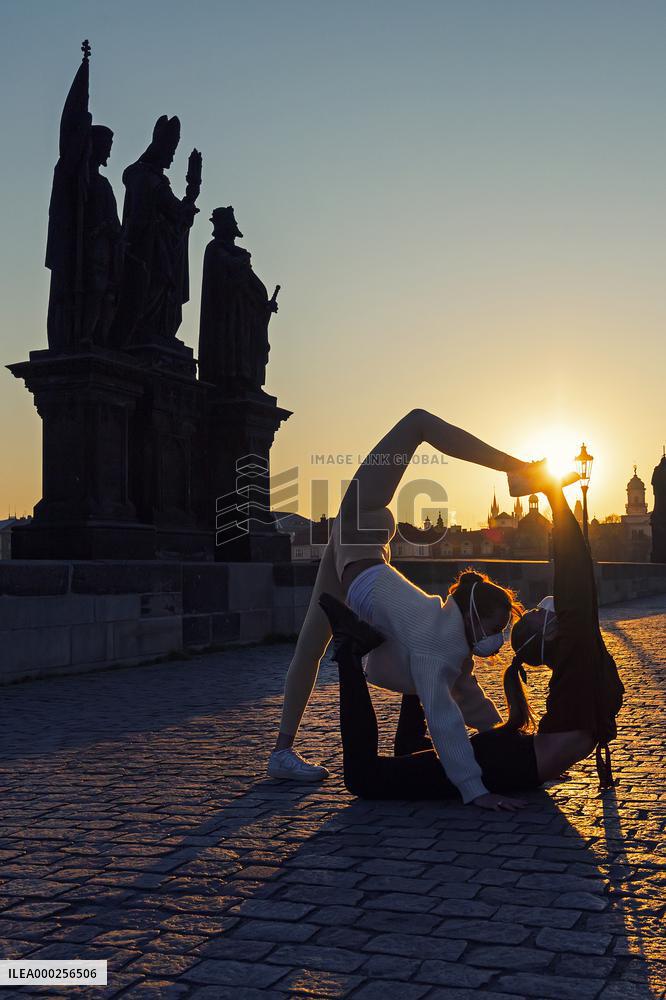 empty Charles Bridge in Prague, girls, yoga