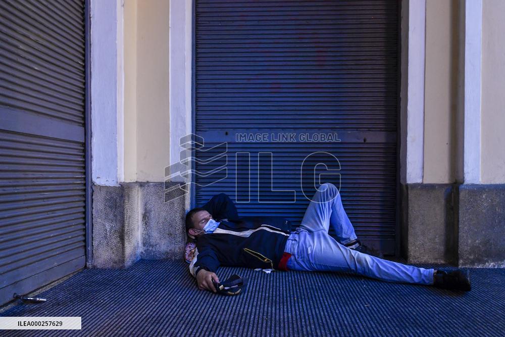 a homeless man in a protection face mask sleeps in Krizovnicka Street in Prague
