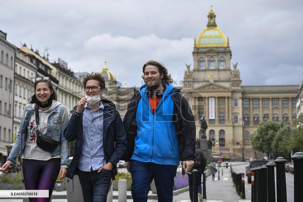 People without face masks walk on Wenceslas Square in Prague