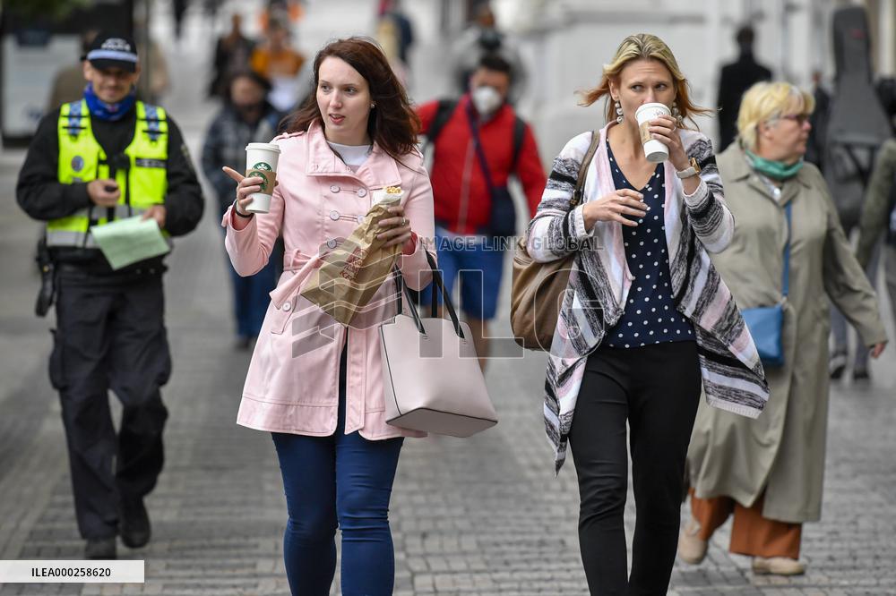 People without face masks walk on Wenceslas Square in Prague