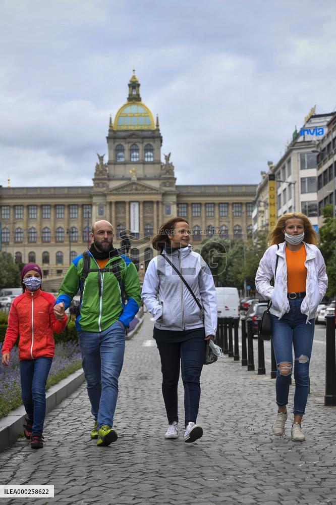 People without face masks walk on Wenceslas Square in Prague