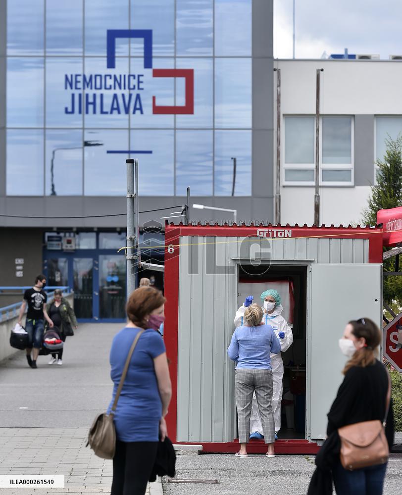 a medic in a protective suit takes a sample for a covid-19 test in the Jihlava hospital testing point