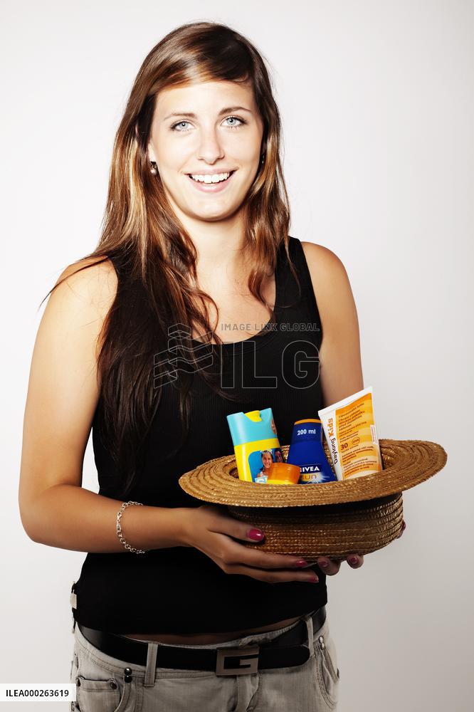 young woman with a hat and sun creams