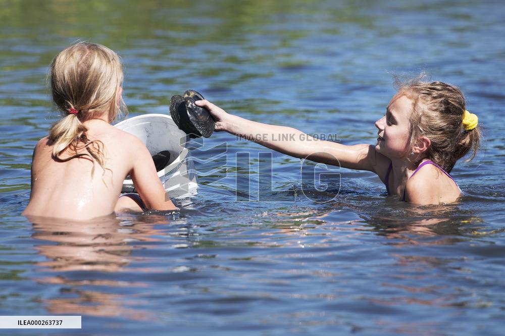volunteers move clams from shallows of the Bolevecky pond in Pilsen
