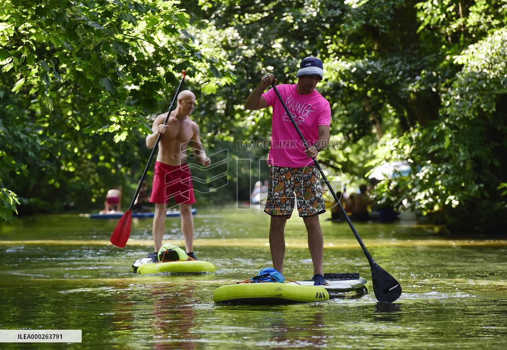 Men ride a stand-up paddleboard in Mlynsky potok
